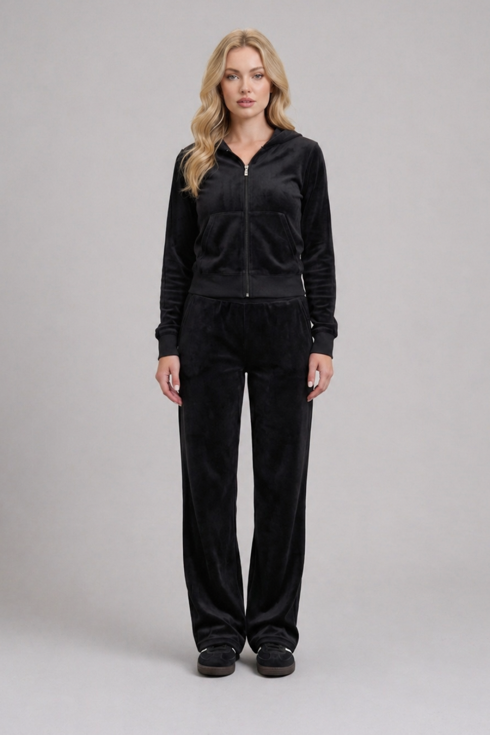 Woman wearing a black tracksuit on a gray background