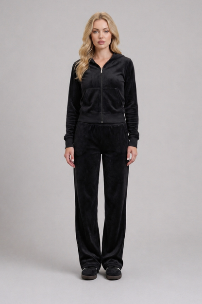 Woman wearing a black tracksuit on a gray background